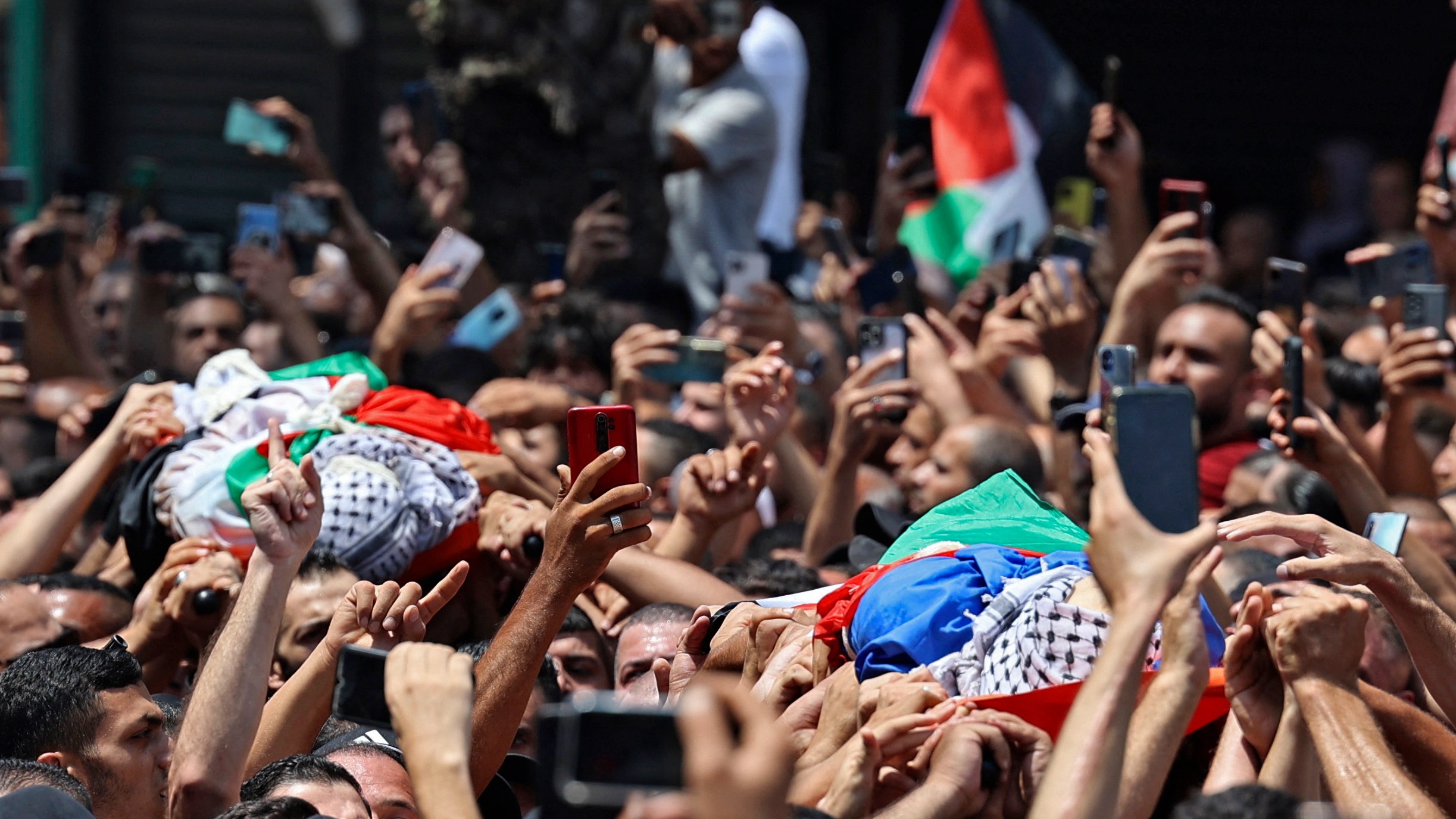 Mourners carry the bodies of Palestinian militants of the Al-Aqsa Martyrs' Brigade Hussein Taha and Islam Sabbouh, who were killed in an Israeli raid, during a funeral procession in the West Bank city of Nablus on August 9, 2022.