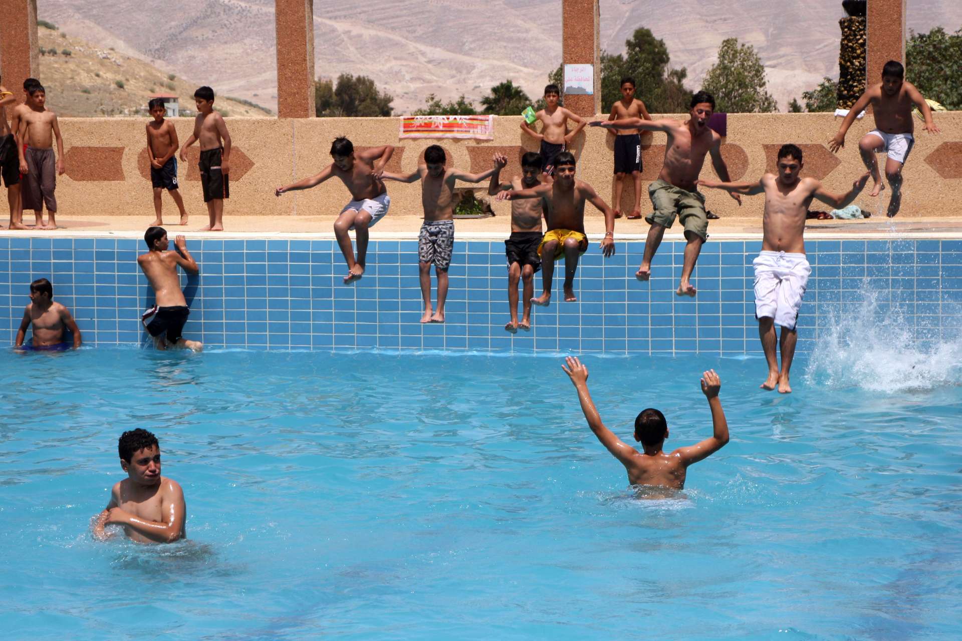 Youths cools off in a swimming pool in Bathan, near Nablus, in a photo taken by Nasser Ishtayer in June 2010 (AP)