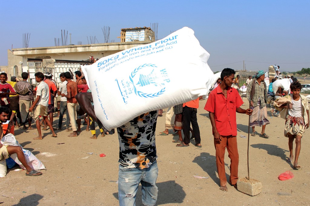 Displaced Yemenis receive humanitarian aid in the northern province of Hajjah on 30 December (AFP)