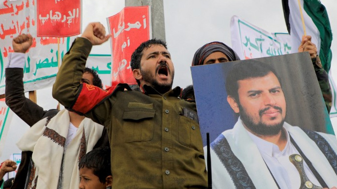 A protester lifts a portrait of Houthi leader Abdel-Malik al-Houthi during a rally against Israel and the US in Sanaa on 19 January 2024 (Mohammed Huwais/AFP)