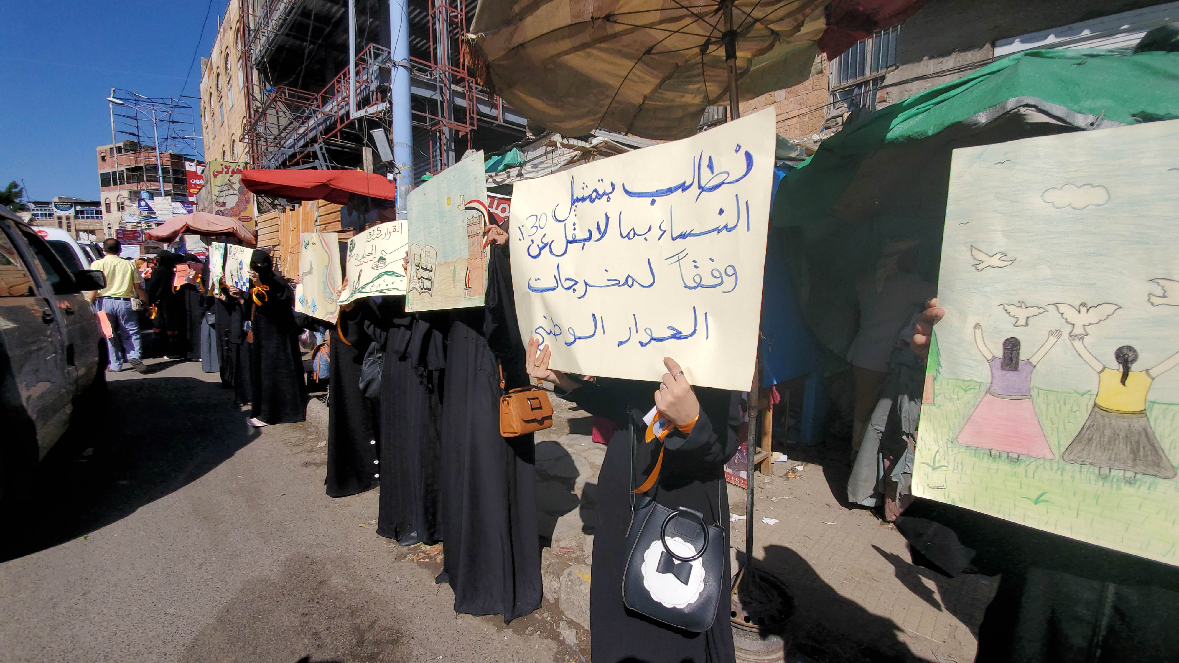 A female protester in Taiz holds a placard reading: 'We demand 30 percent representation for women based on the Outcomes of the National Dialogue Conference' (MEE)