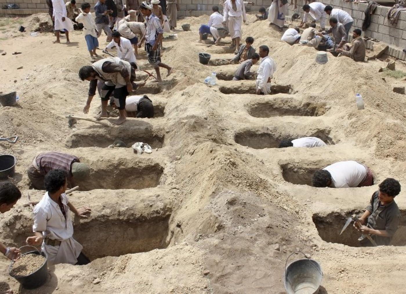 Yemenis dig graves for children, who where killed when their bus was bombed by Saudi-led coalition (AFP)